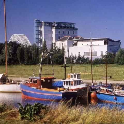 Catalyst Science Discovery Centre & Museum, Widnes — the Gossage Building with rooftop Observatory Gallery, photographed across the marina with the Silver Jubilee Bridge in the distance.