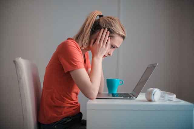 Woman sat at a desk with WiFi connectivity issues